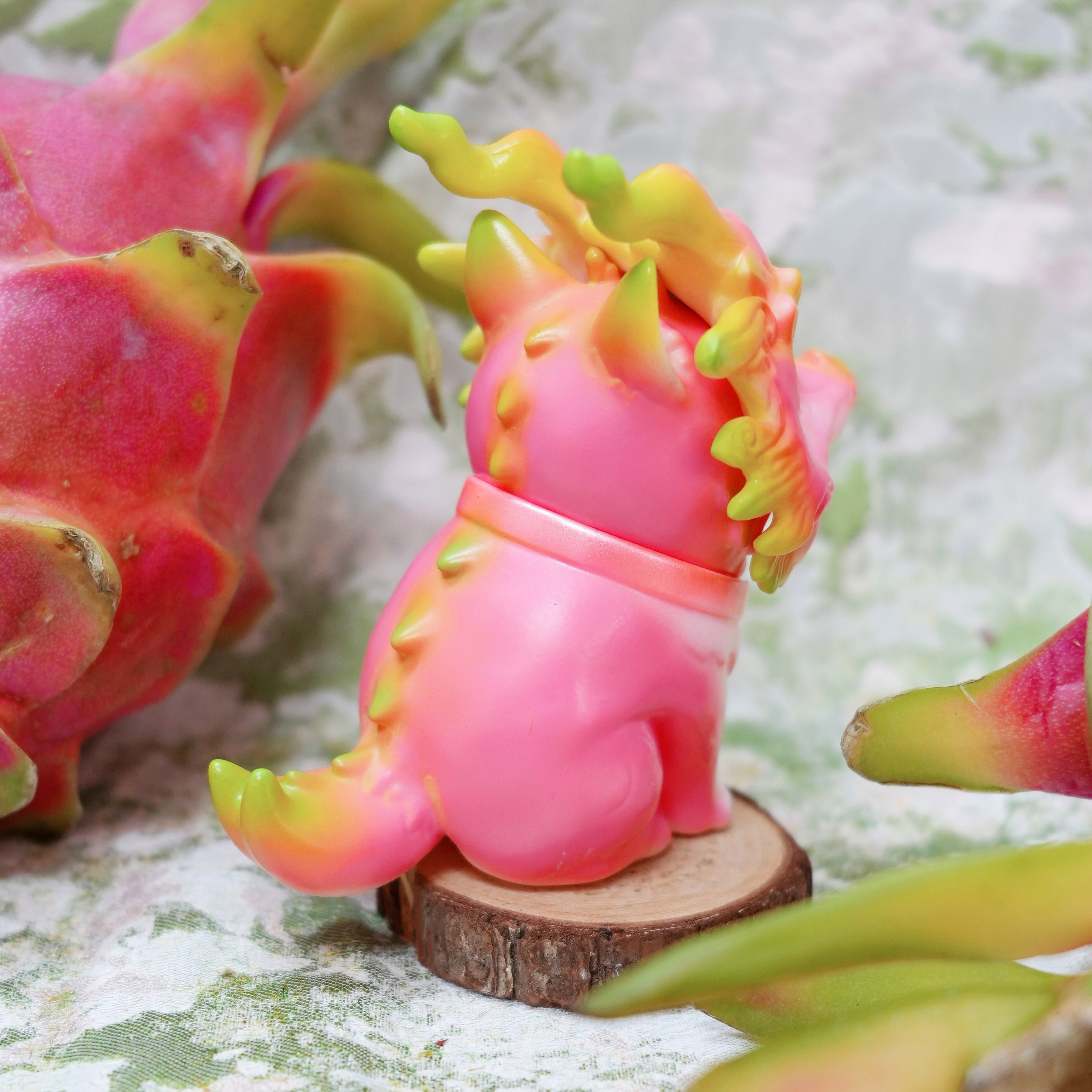 Pitaya Loong cat by HOTRU, a vibrant vinyl figurine with dragon fruit, showcasing its rotatable head and magnetic mask, available for preorder.