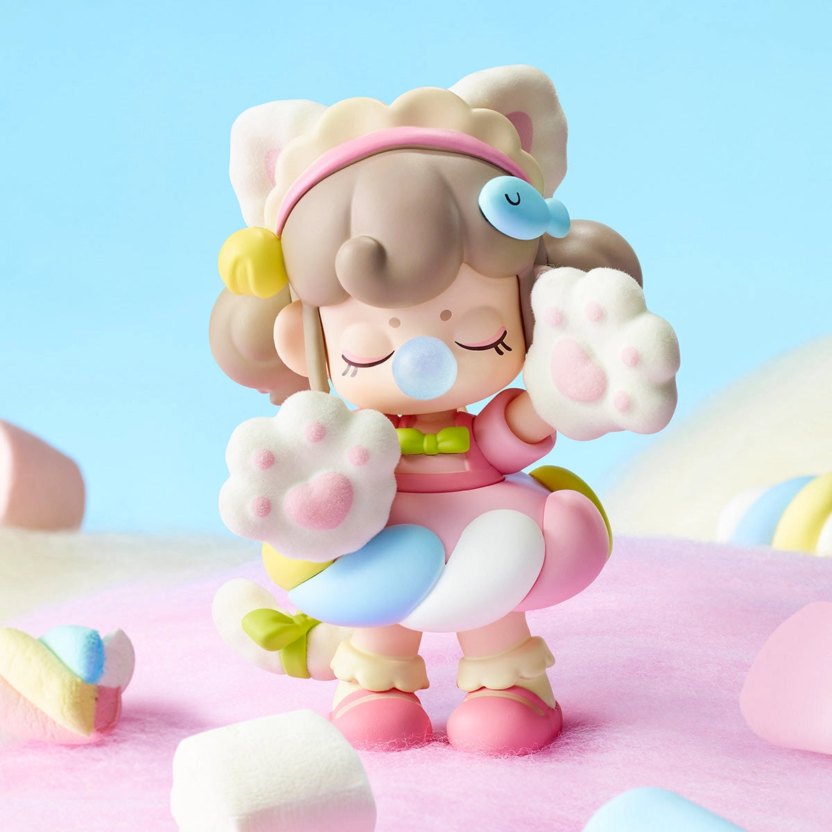Chibi girl figurine from Nanci's Sweet Time Blind Box Series, in cat-ear gear and paw mittens, stands on a pink surface with marshmallow shapes.