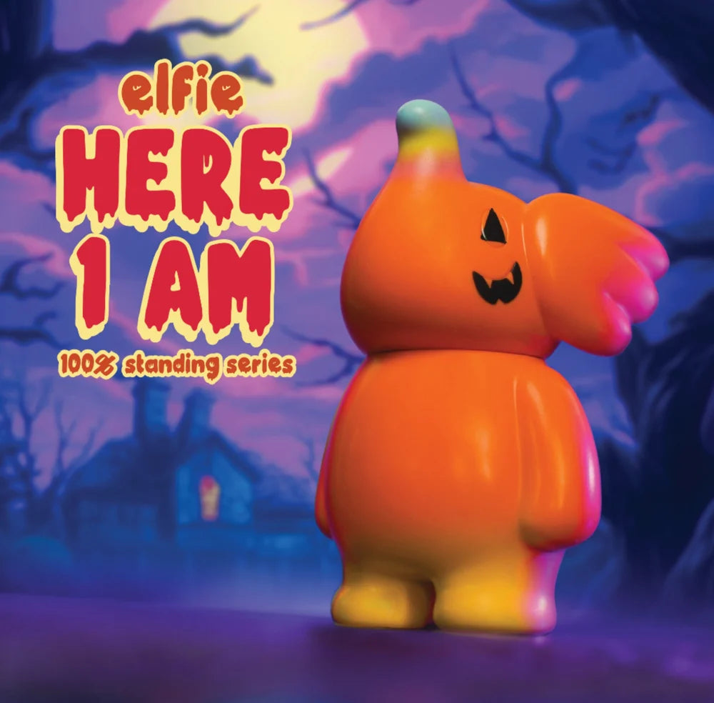 ELFIE HERE I AM! 100% PUMPKIN EDITION vinyl toy, featuring a round body, pumpkin face, and rainbow-tinted horn, set against a haunted backdrop.