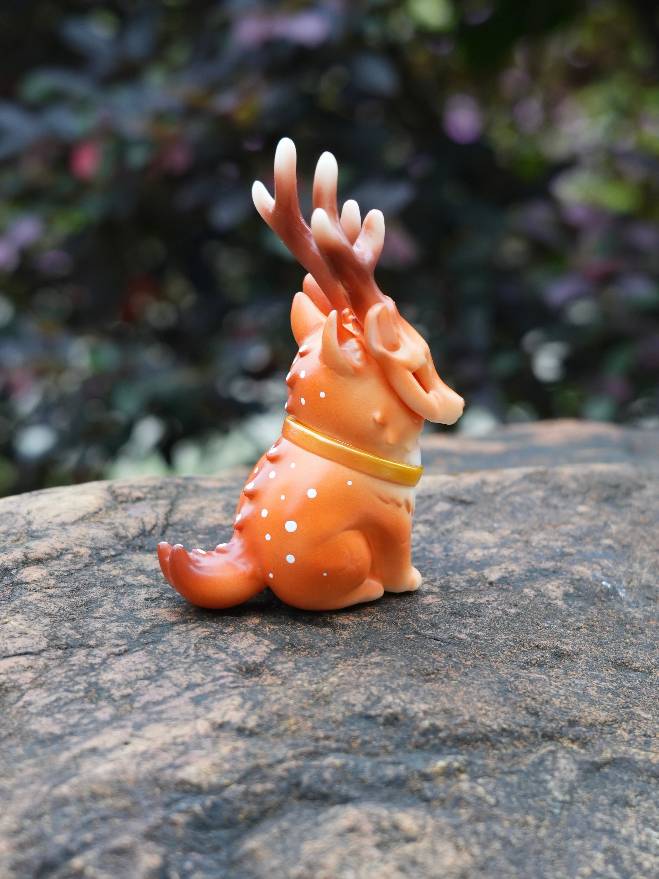 Spotted Deer Cat by HOTRU - Preorder: A 6.5cm orange vinyl toy with antler horns, rotatable head, and white spots, on a stone surface.