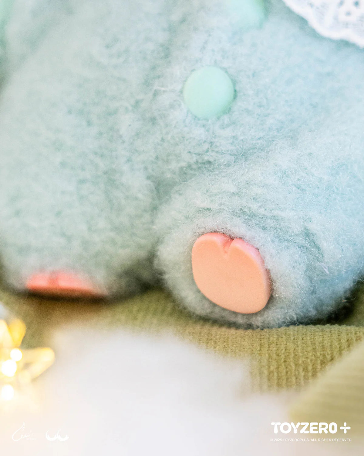 LuLu the Piggy plush in pastel mint, featuring a pink heart-shaped pad, button detail, on a cozy surface. Part of LuLu's Dreaming Wonderland Series.