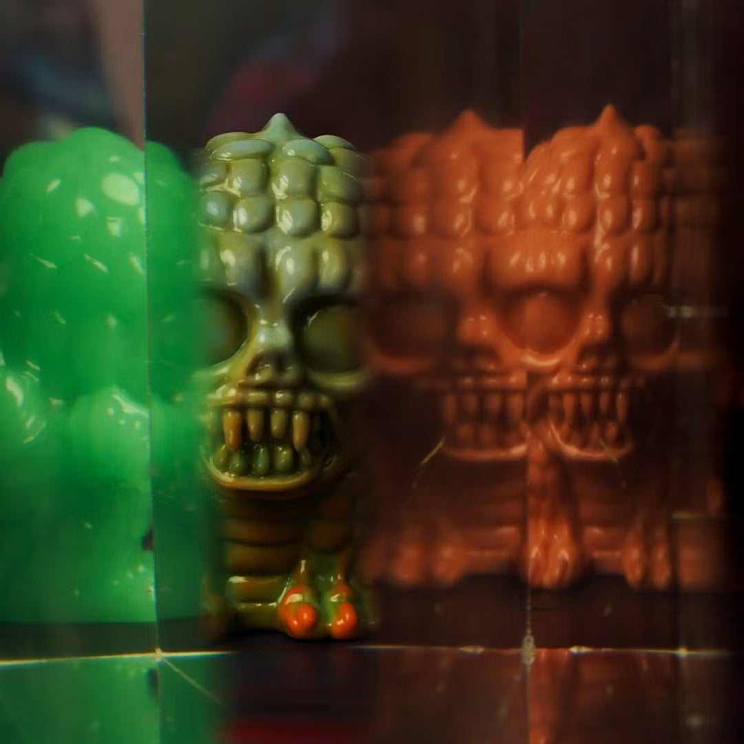 Retroband & Zectron's WHO GOES THERE? VERSUS Blind Box Series features a small skull figurine with tinted reflections, crafted from soft vinyl.