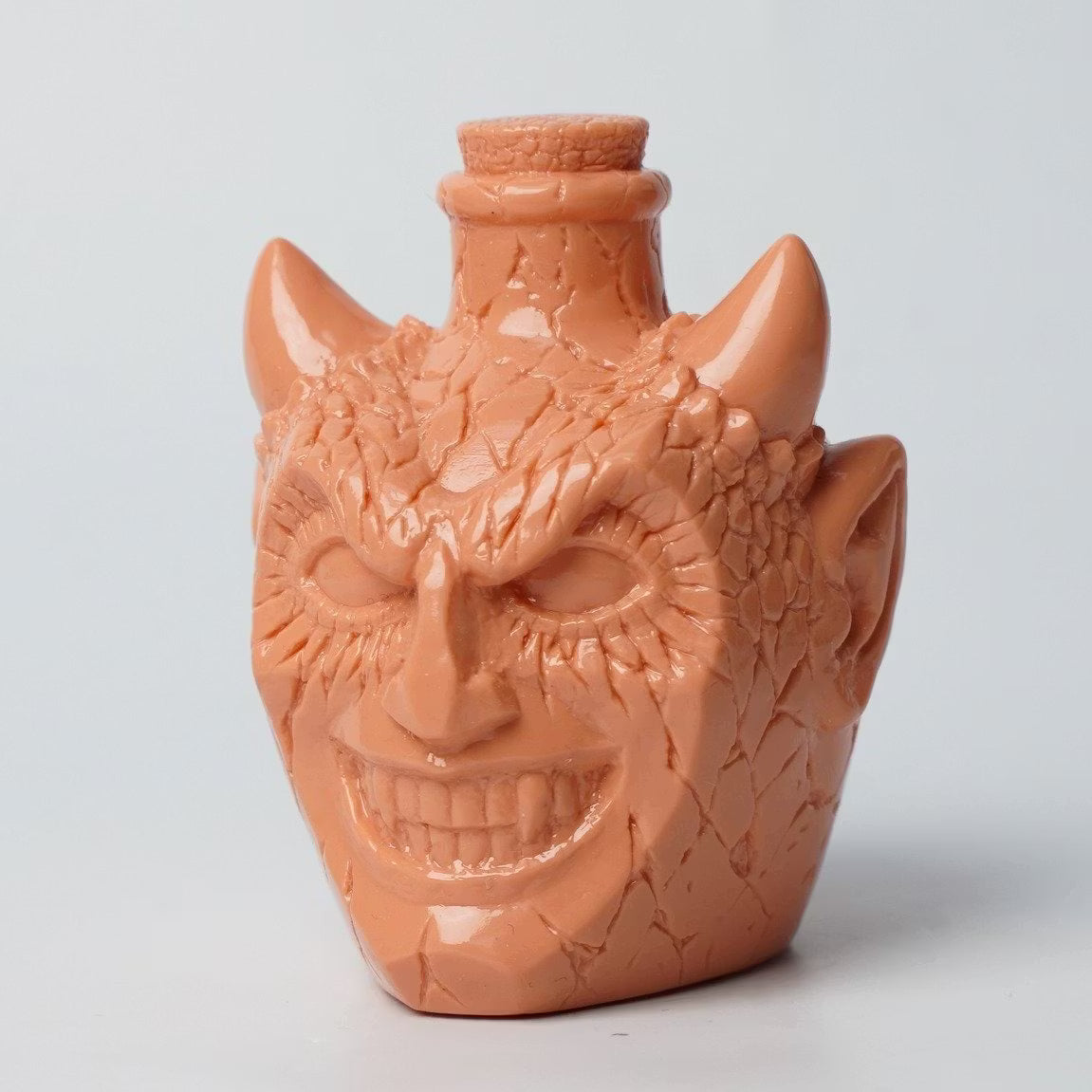 Retroband & Zectron Presents WHO GOES THERE? VERSUS Blind Box Series: Reddish-orange demon head sculpture with horns and toothy grin, featuring a stopper at the top.