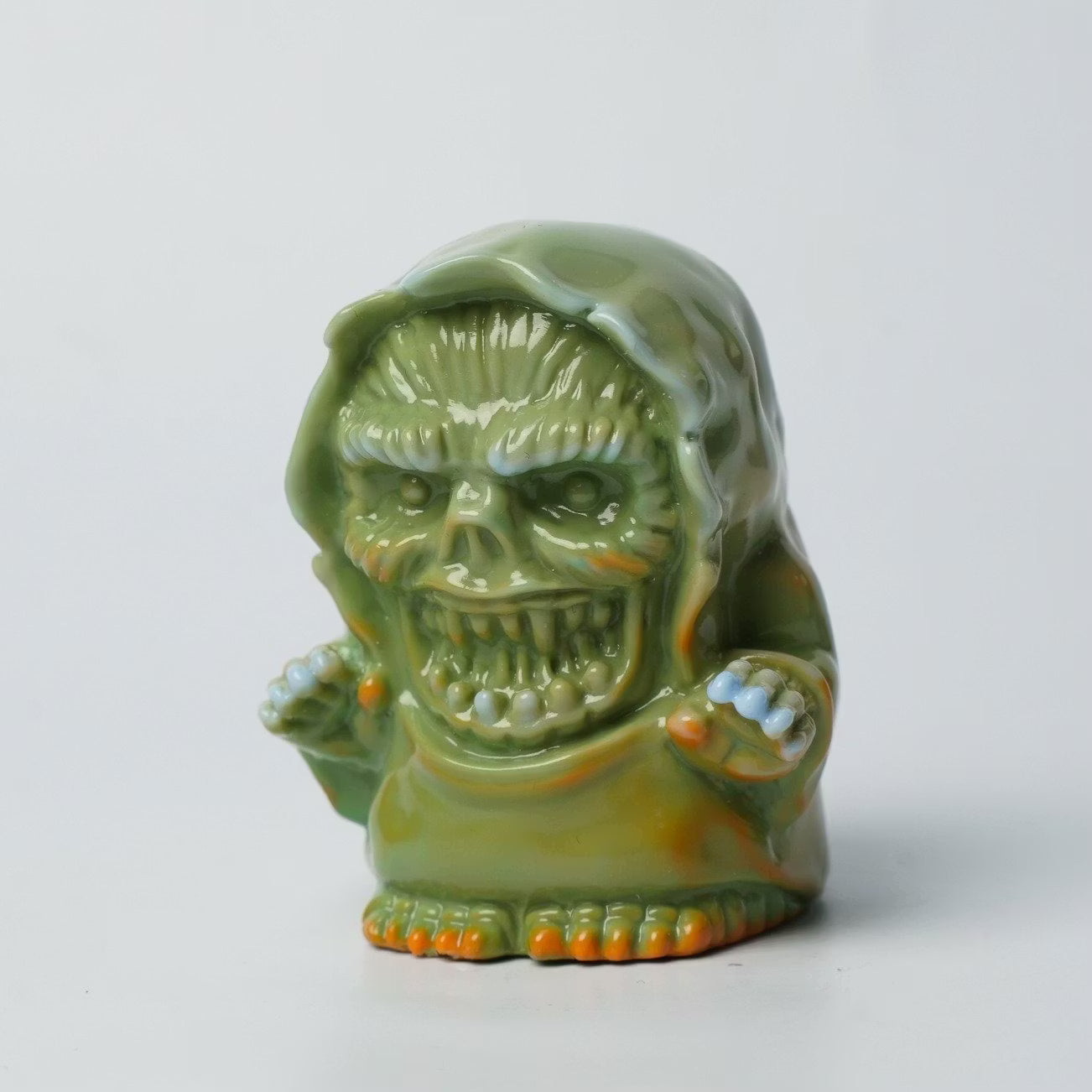 Retroband & Zectron's WHO GOES THERE? VERSUS features a glossy olive-green sofubi-style hooded monster toy with jagged teeth and bulbous eyes, perfect for collectors.