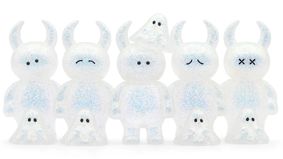 Five UAMOU WHITE OPAL vinyl figures with horn-like ears and simple faces, each paired with a tiny ghost companion; third figure has an extra ghost on its head.