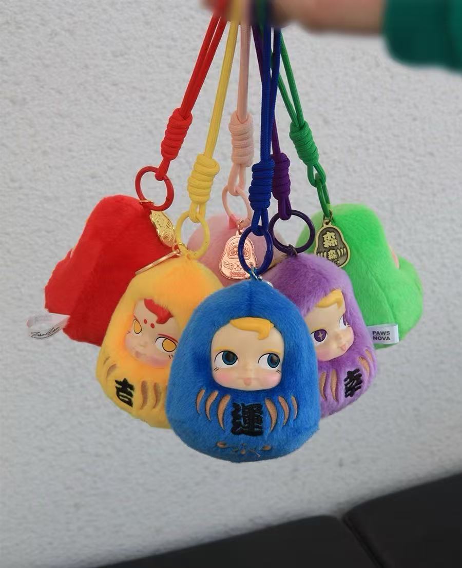 DHARMA SAMSAM VINYL FACE PLUSH PENDANT BLIND BOX: Handful of colorful plush key-ring charms, each with a cartoon face, perfect for accessorizing bags or keys.