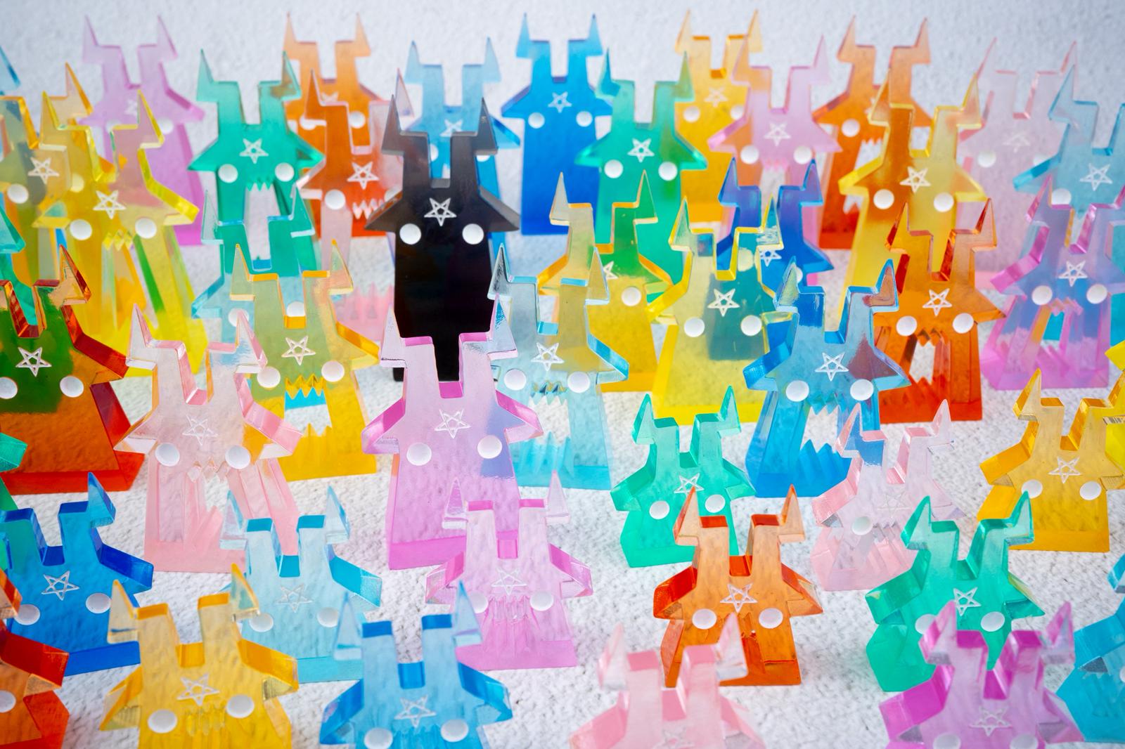 Phillips blind bag by Zintears: A collection of small, acrylic monster figures with horns and star motifs, available in various colors, arranged on a tabletop.
