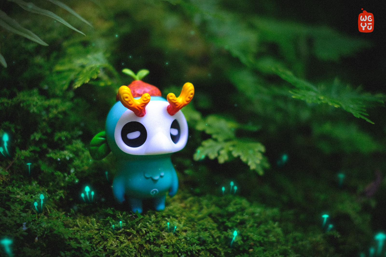 Ori muffinn by Madkids: A teal creature figurine with white face, orange horns, and sprout, on a mossy forest floor with glowing mushrooms.