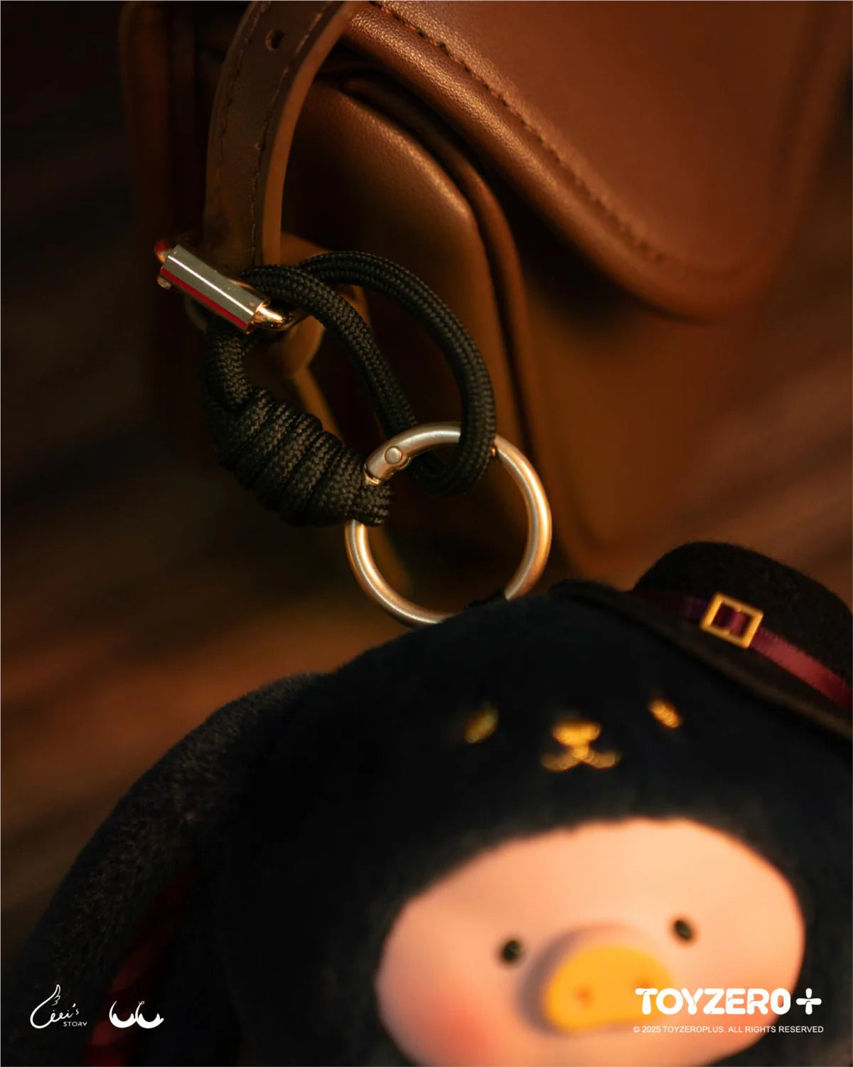 Close-up of LuLu the Piggy - Vinyl Face Plush Keychain (Magician Bunny LuLu ver.), featuring a black hood and tiny vintage clock, attached to a leather bag.