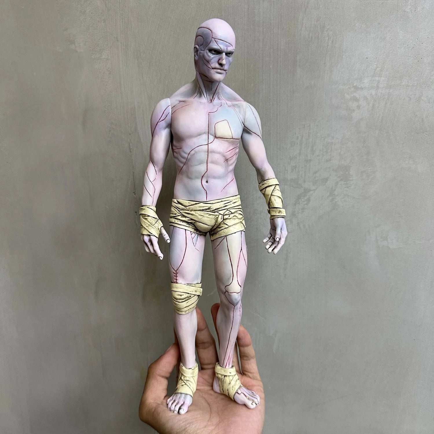 Hand holding a 30cm soft vinyl figurine of Frankenstein's Creature V1, showcasing stylized anatomical lines and bandages, capturing gothic artistry and cinematic reinterpretation.
