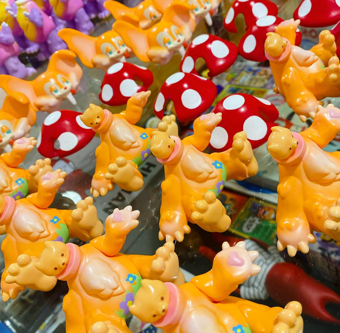 Mushroom by Vivian Wang: Soft vinyl toy display featuring orange cat-headed figures and red-spotted mushrooms, highlighting whimsical art toys at Strangecat Toys.
