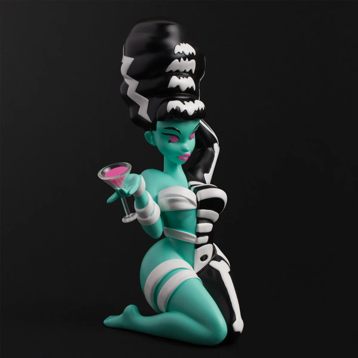 Bride Bones LIMITED EDITION RESIN FIGURE: A stylized, pin-up monster bride with aqua skin, black beehive, and skeleton-bandaged attire, holding a pink cocktail.