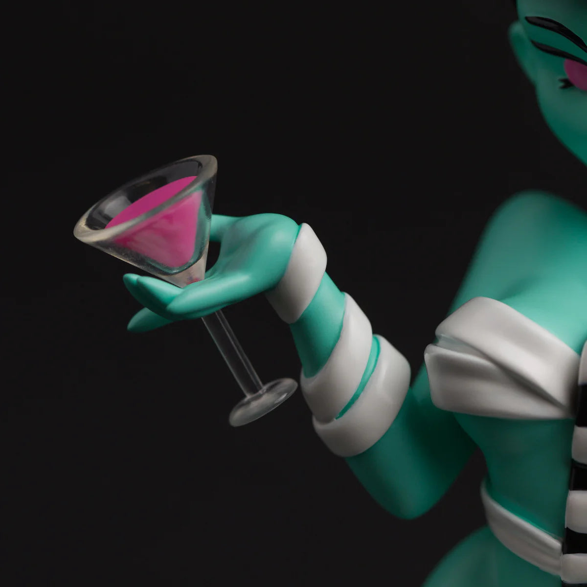 Bride Bones LIMITED EDITION RESIN FIGURE: Turquoise arm with cuff holds a pink martini glass, showcasing this collectible's punk-horror fusion.