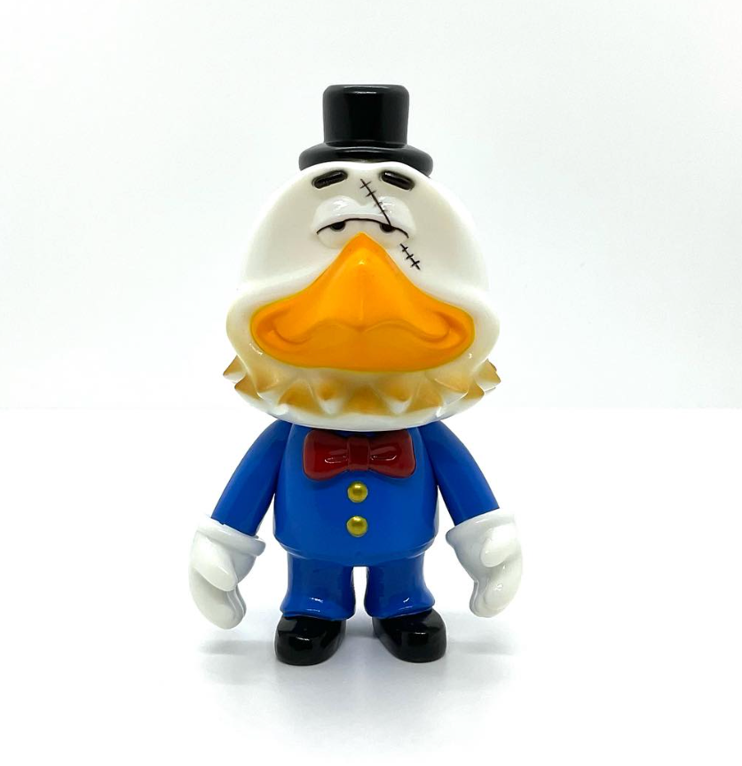 SwingBird Mini by Swingtoys: a 13cm vinyl toy of an anthropomorphic duck in a blue suit, red bow tie, and top hat, featuring a whimsical stitched scar detail.