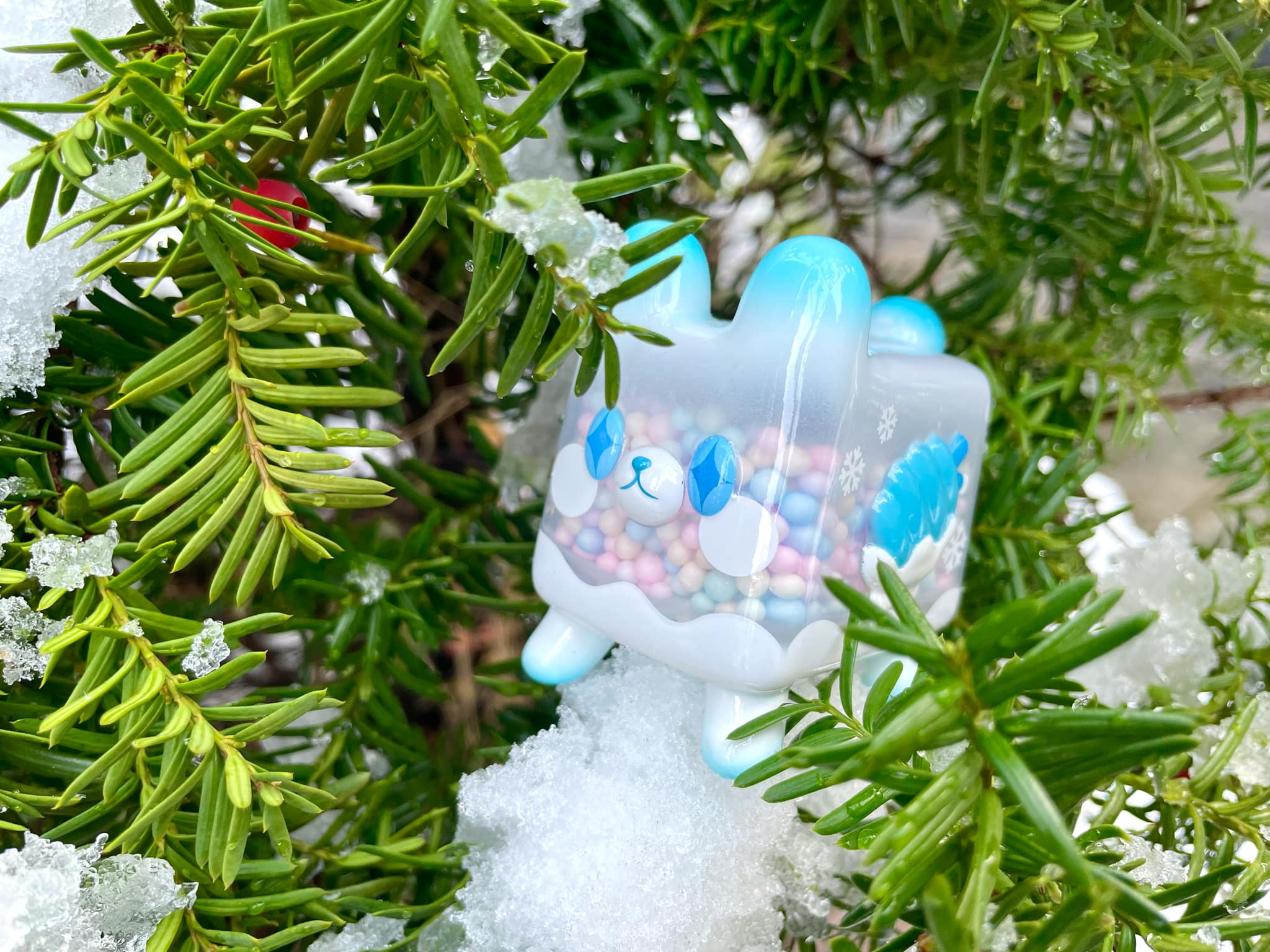 Box Bear - Snow Ver. by Rato Kim, a limited edition vinyl toy, nestled in a tree, showcasing a blue and white animal face.