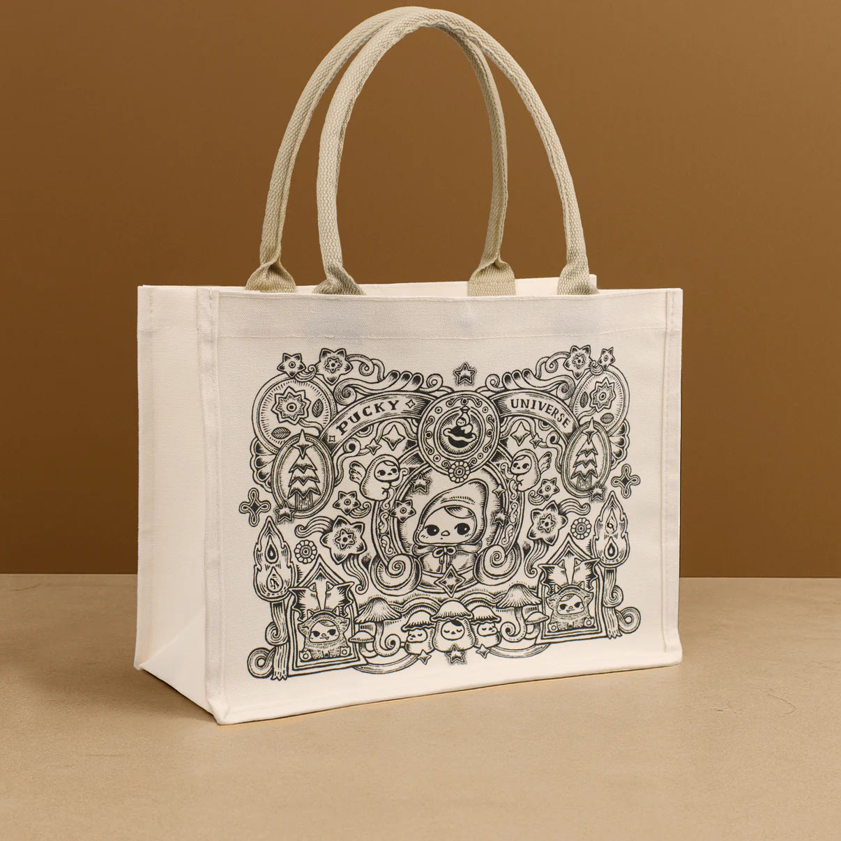 Tote bag - Pucky Universe - Preorder featuring whimsical, cartoon-style art with a hooded figure and creatures, on natural cotton canvas with sturdy handles.