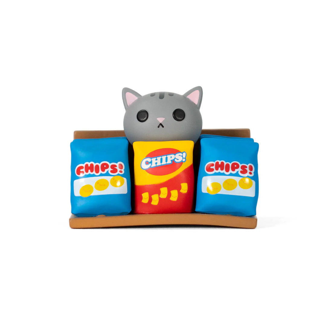 Bodega Kitties Mystery Series 2 Boxes by 100% Soft, featuring a gray cat figurine behind three CHIPS! bags, embodying playful surprises from Strangecat Toys.
