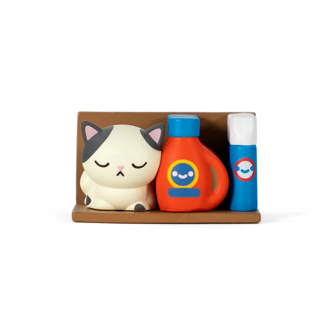 Bodega Kitties Mystery Series 2 Boxes by 100% Soft featuring a sleeping cat, smiling bottle, and tube on a brown shelf display.