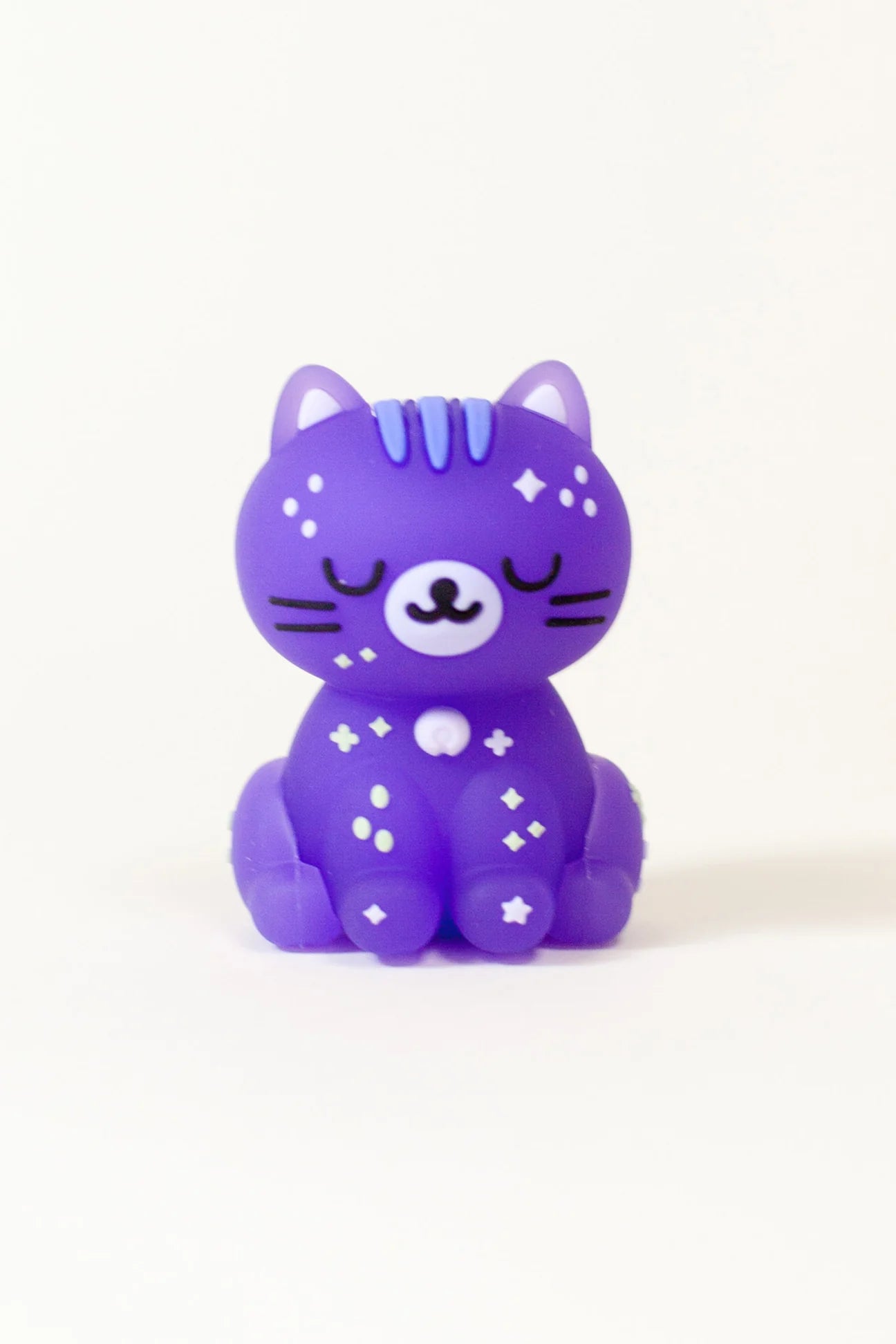 Smoko Astro Cats Blind Box Figure: A purple rubber cat figurine with closed eyes and star patterns, part of a collectible series from Strangecat Toys.