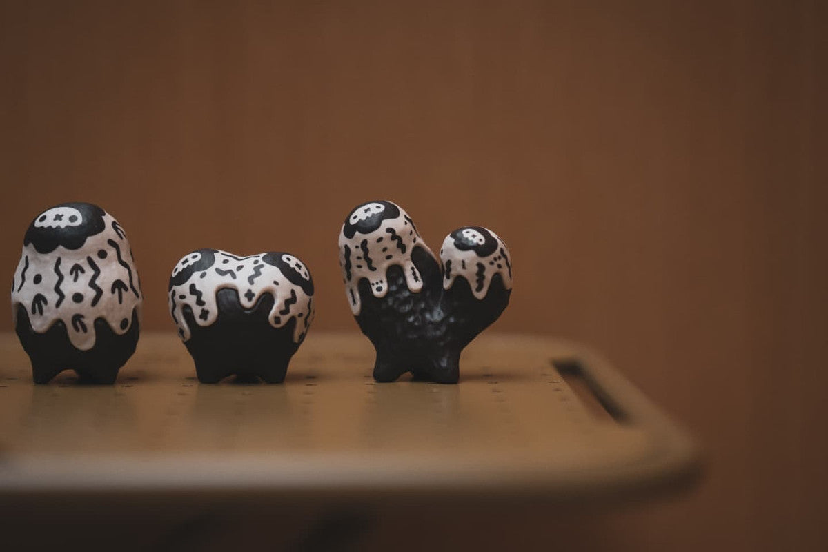 Copiapoa Mudball Blind Box Series by Robin Huang, featuring black and white ceramic heart with skulls, part of a 6-design collection with secret options.