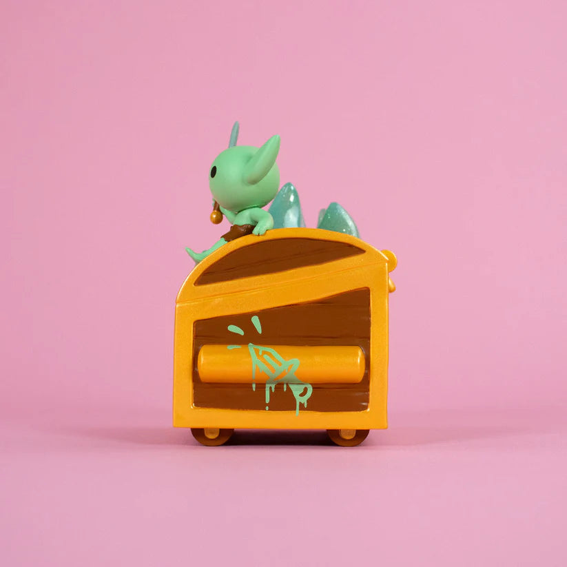 Wizard of Barge Dumpster Fire Vinyl Figure perched on a wheeled box, featuring a green creature with detachable sword, wearing a bell and shorts. Preorder available.
