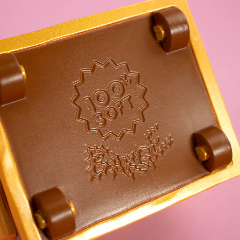 Close-up of a fingerboard's underside with 100% SOFT on the deck. Preorder Wizard of Barge Dumpster Fire Vinyl Figure, featuring detachable sword.