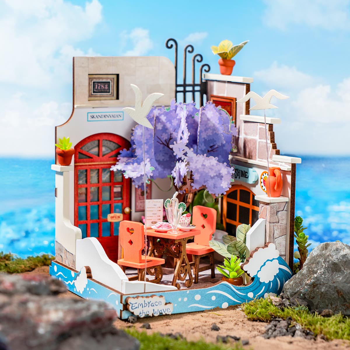 Rolife Sea Holiday Restaurant DIY Miniature House DS039 kit featuring a beach-themed scene with a toy house, table, chairs, and seaside dining elements.