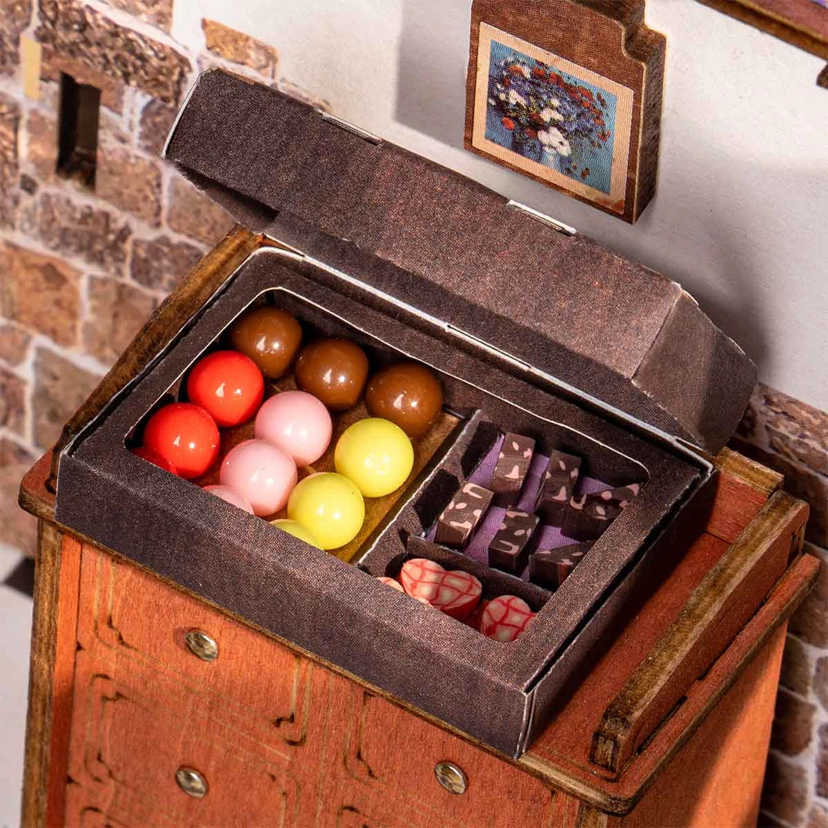 DG174 Henry's Chocolate Rolife DIY Miniature House features a detailed candy-box vignette with gumballs, patterned chocolates, and marbled candies, perfect for art toy enthusiasts.