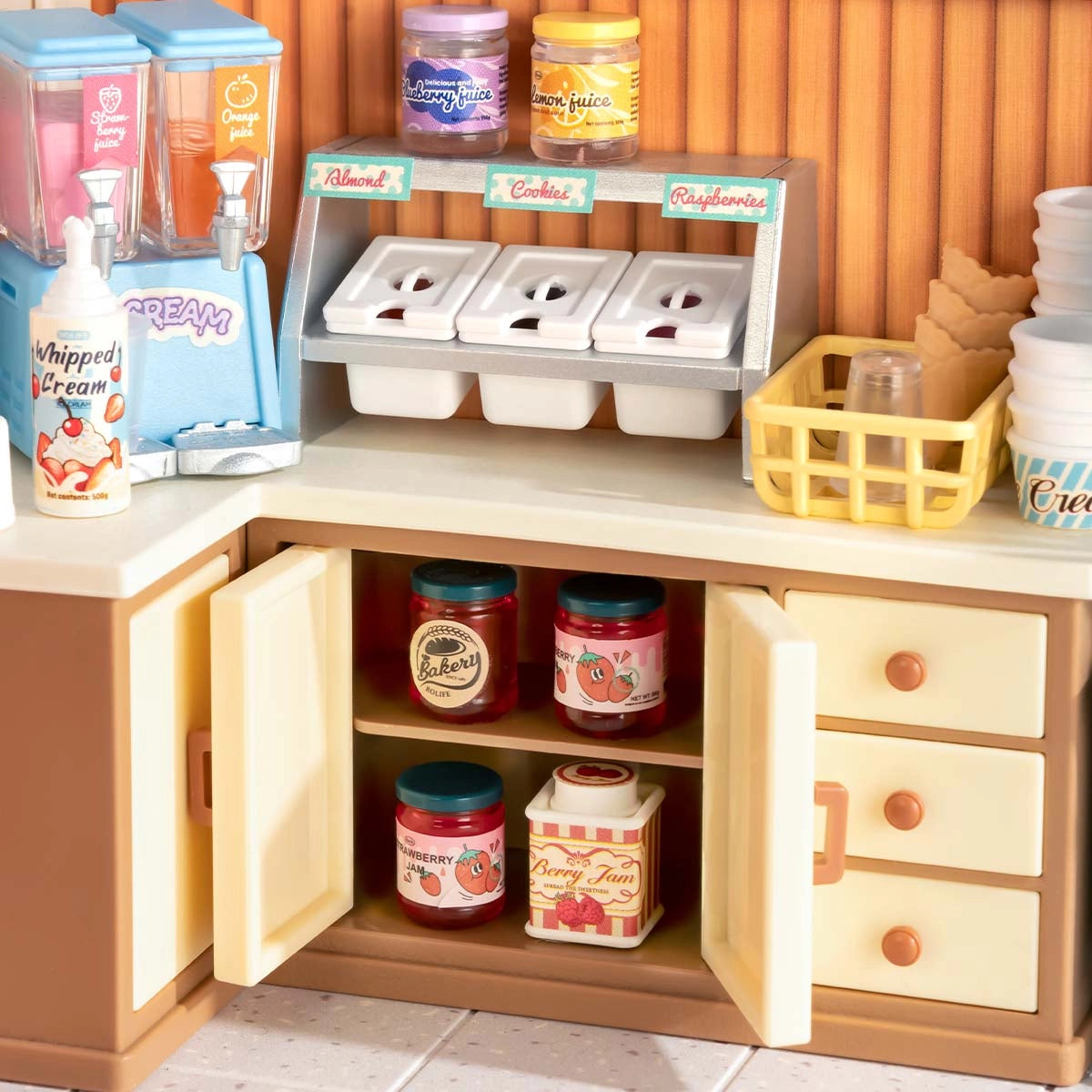 DW018B Flavorful Ice Cream Rolife DIY Miniature House features a toy dessert counter with juice dispensers, toppings rack, waffle dishes, and miniature jam jars.