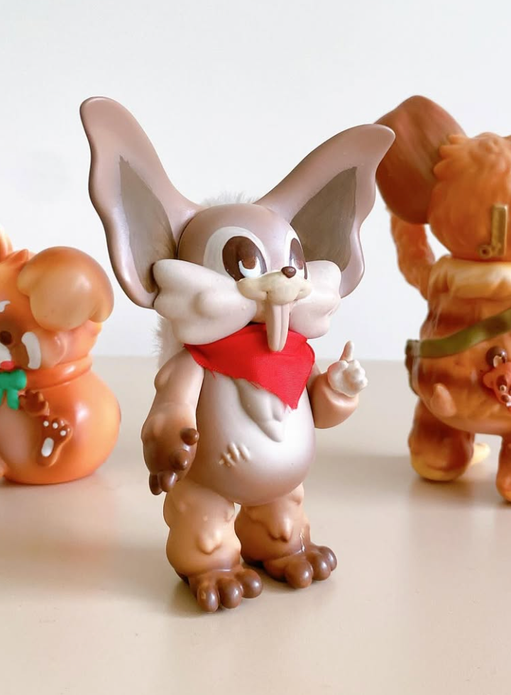 Thief Raccoons by Vivian Wang: A small designer vinyl figure, featuring a tusked anthropomorphic animal with a red bandana, part of a series in warm tones.