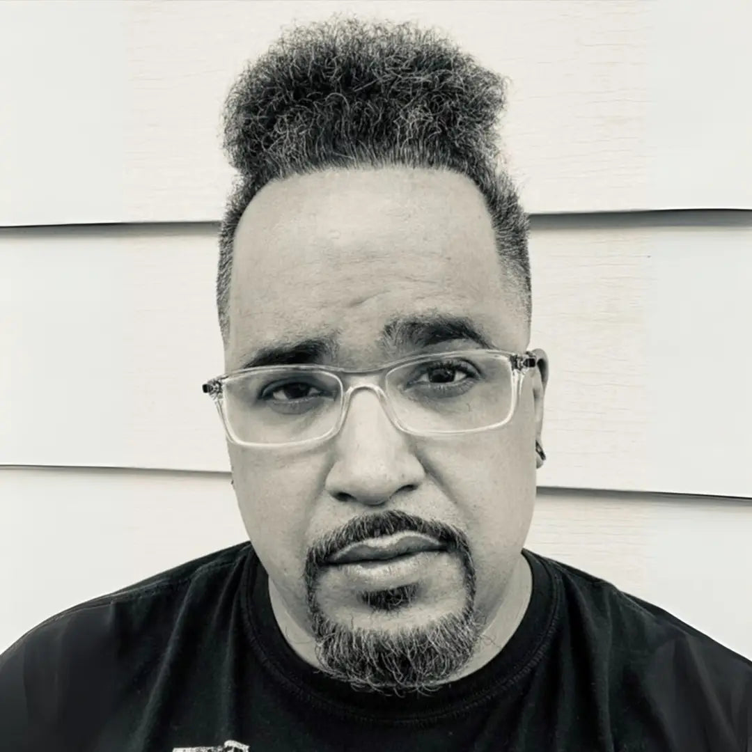 Close-up of an adult wearing clear-framed glasses, representing the Art Pickagram 3D Puzzle X Artist_04 Xavier Alvarez, a limited edition interactive art puzzle.