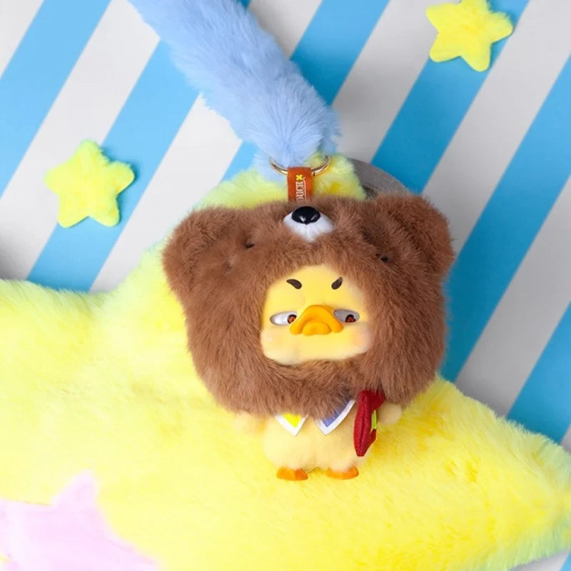Upset Duck - Pocket Crazy Circus Duck features a yellow duck in a bear hat, sitting on a star cushion, attached to a fluffy blue strap.