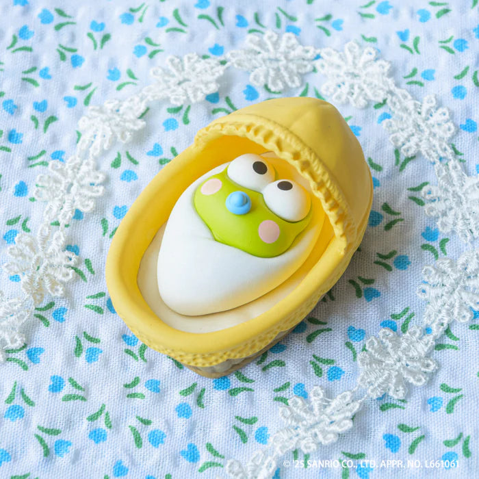 Sanrio Characters Baby Room Collection 2nd Edition Gacha Series featuring Keroppi in a yellow bassinet with a blue pacifier, wrapped in a white blanket.