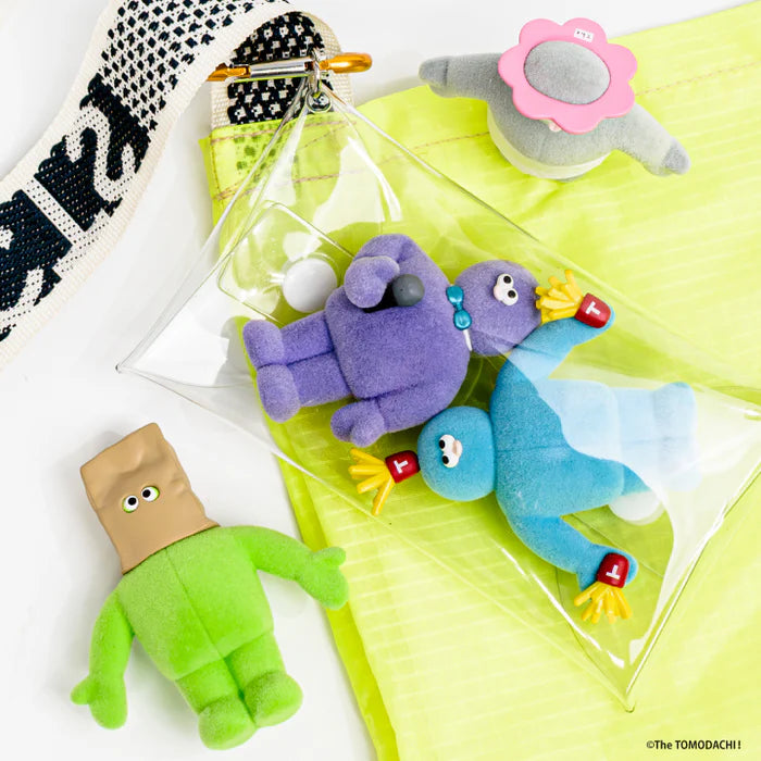 The TOMODACHI! Figure Collection 3 Gacha Series: Four colorful plush keychains, including a green humanoid, displayed against neon-yellow backing with a clear pouch.