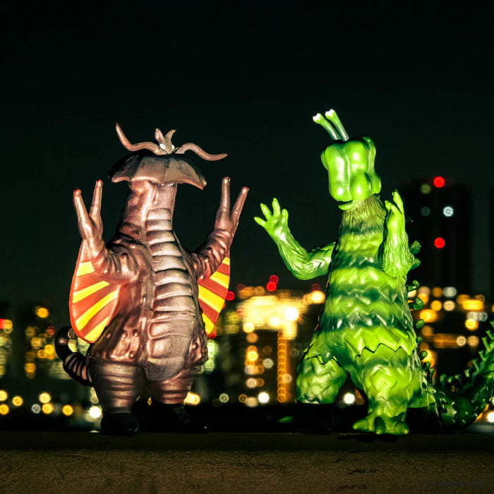 Two stylized monster figures from Takuma Fujisaki's 3D Monster Encyclopedia: Tokyo Monster Universe Vol. 2 Gacha, standing on a rooftop with a city skyline backdrop.