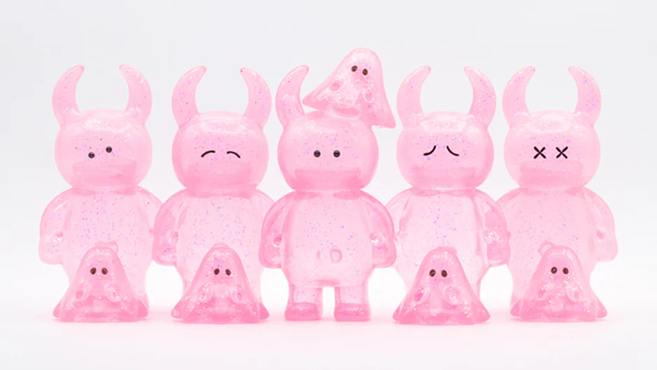 UAMOU CLEAR PINK GLITTER: A lineup of five translucent, glittery monster figures with horn-topped heads and matching ghost companions, crafted from soft vinyl, 7cm tall.