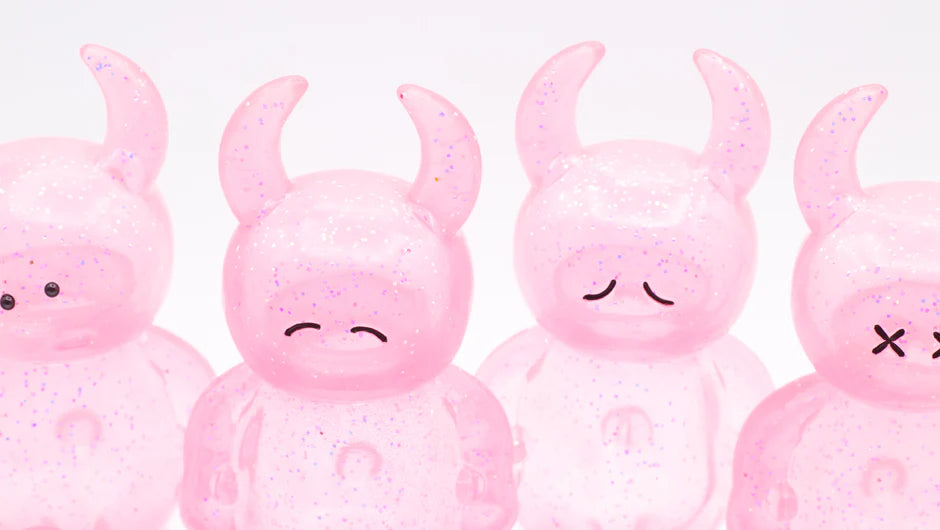 UAMOU CLEAR PINK GLITTER figures, 7cm tall, translucent and glitter-filled, each with unique painted expressions and horns, crafted from soft vinyl in Japan.