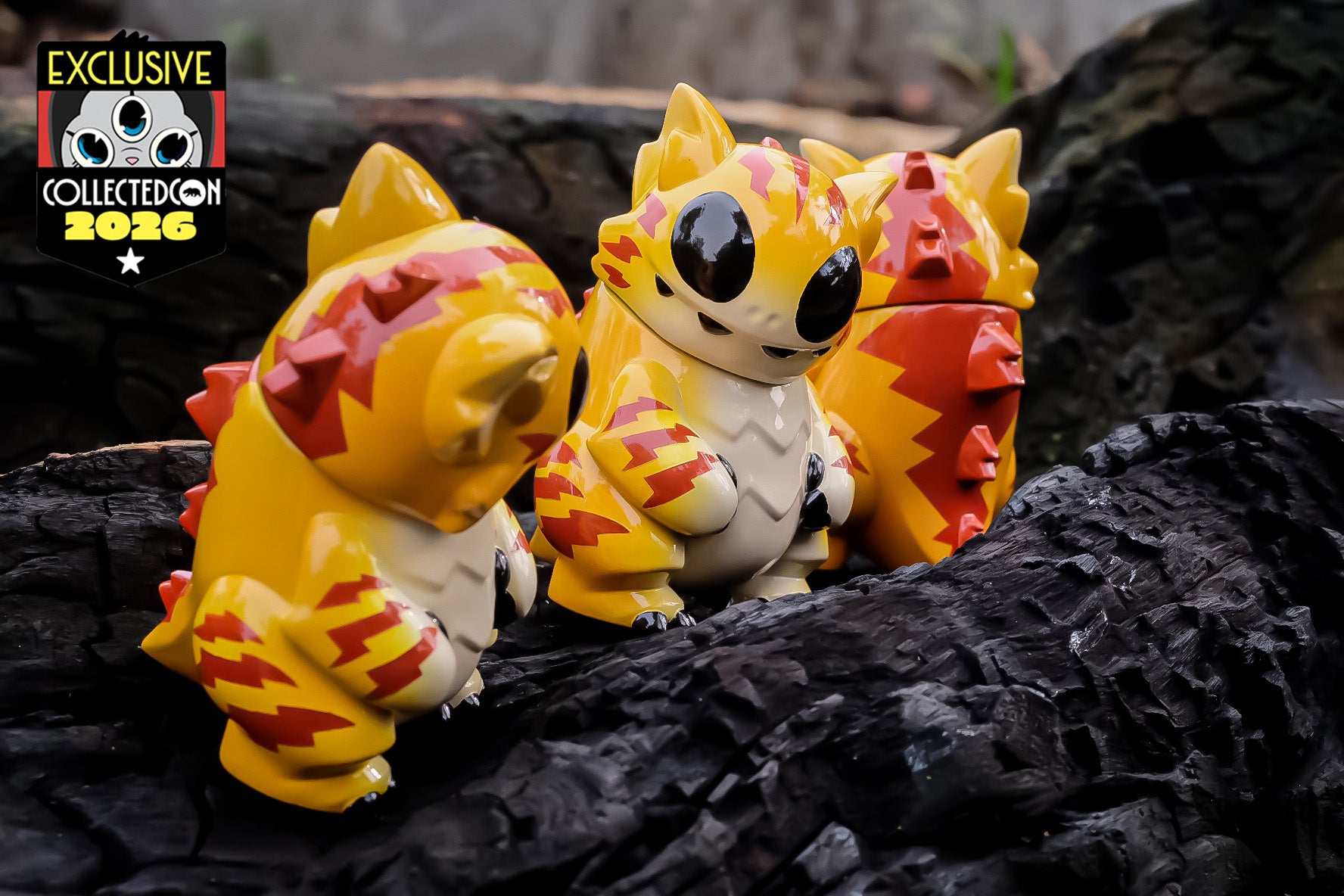 Oddzilla Oyen Sofubi by Iky: trio of exclusive collectible figures with spikes, glossy eyes, and lightning stripes, perched on charred wood. Limited to 30 pieces.