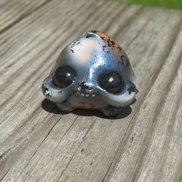 Little Shit Bigger Deal - Beasties Bites by Dear Beasties x Trash Panda, a small toy with a face, displayed on a wooden surface.