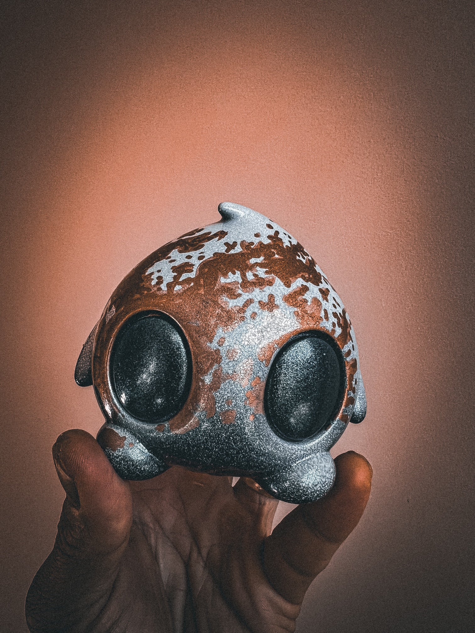 Hand holding a mixed-media toy titled Bite Me - Bites by Mecha Panda, featuring a black oval design, exclusive to Strangecat Toys.