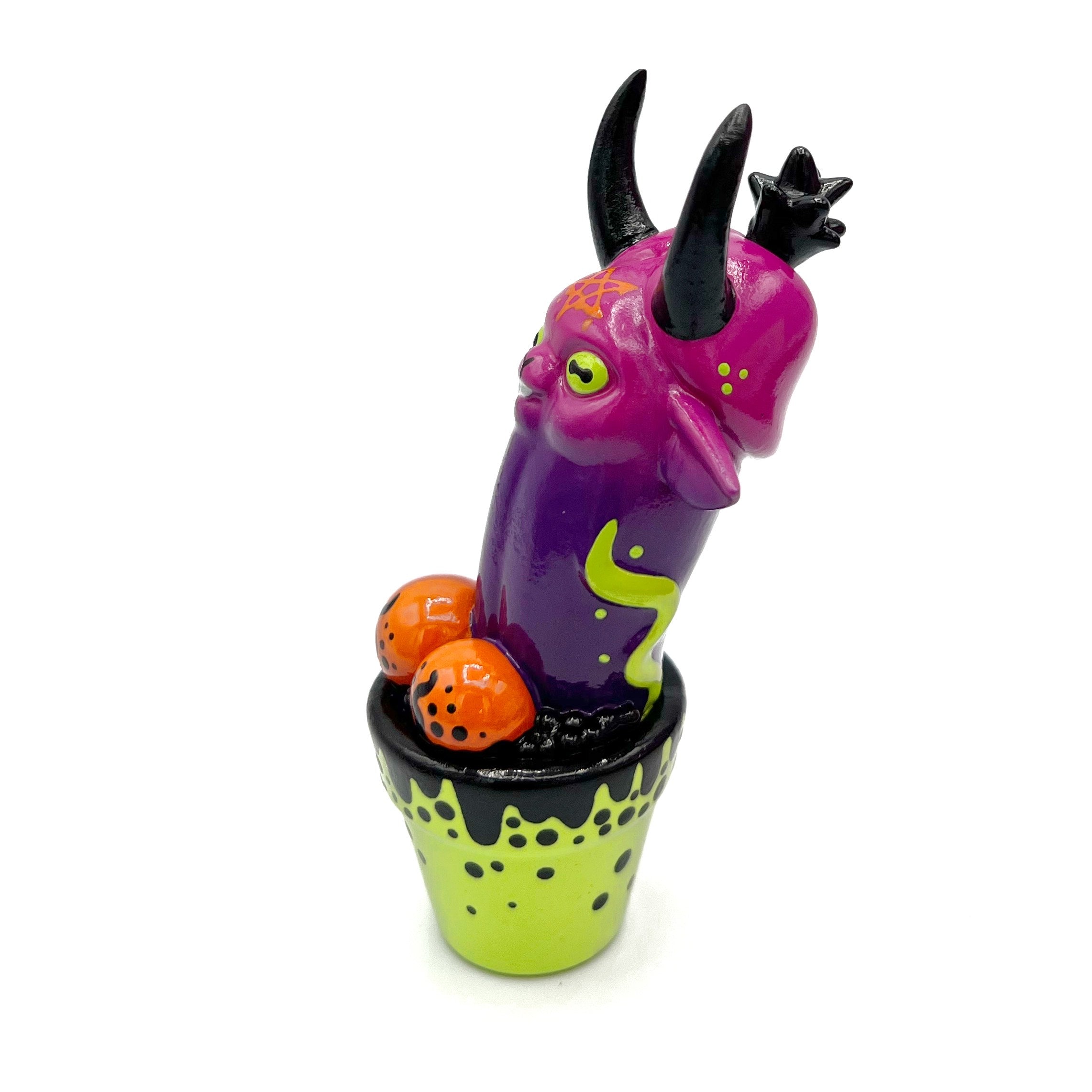 Monster figurine with yellow eyeball, colorful cup, and group of orange objects, part of Simon Says Macy & Friends - East Van Satan by Ghostfox Toys.