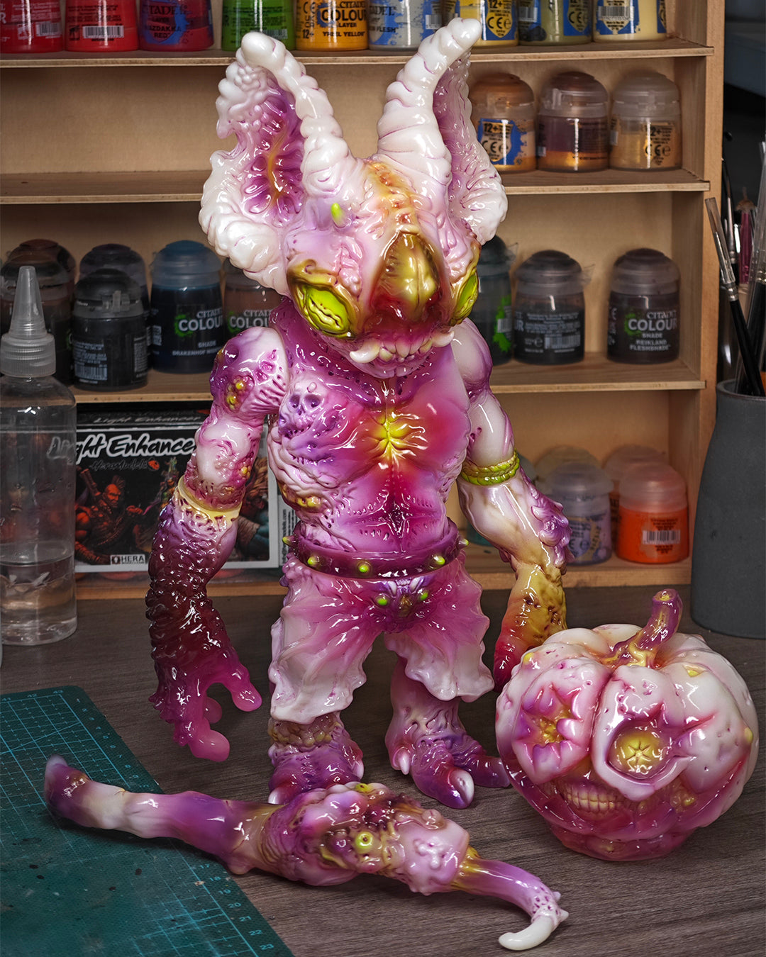 NPK · Poison Veil Ver. & Jack o’ Lantern III preordered art toys on a hobby bench, featuring a monster figure, pumpkin accessory, and crafting tools.