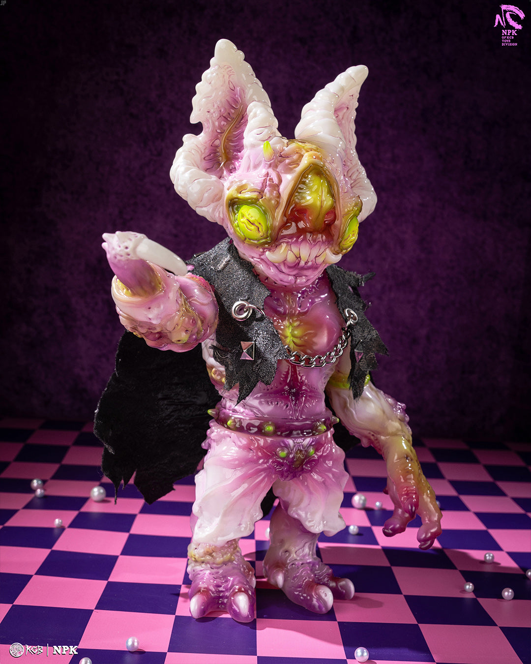 Stylized vinyl figure, NPK · Poison Veil Ver., with mutant features, punk attire, and accessories on a checkerboard floor. Includes cloak and coffin bag. Preorder available.