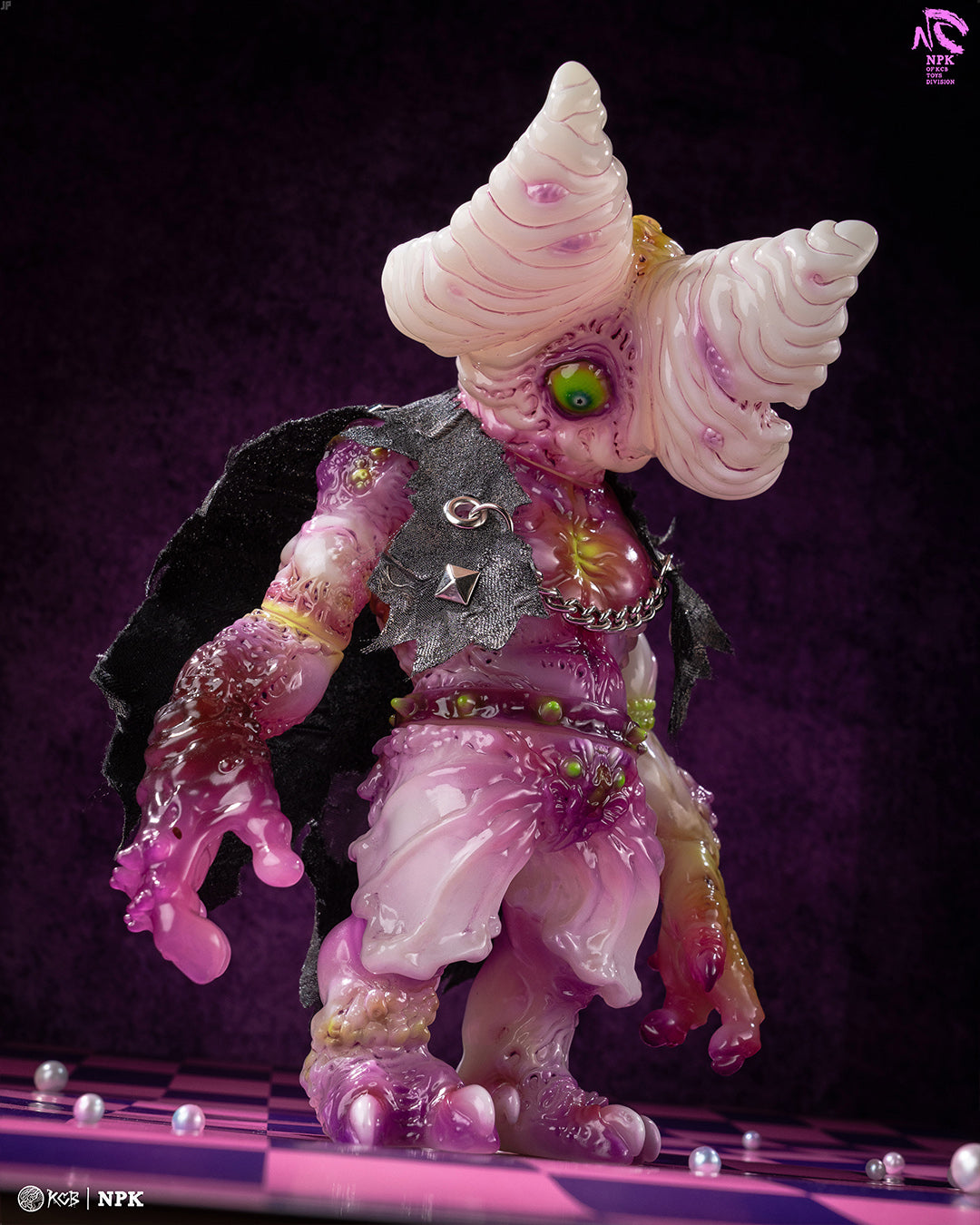 NPK · Poison Veil Ver. figure with melting texture, ice cream horns, green eye, and black cape on a checkerboard surface, highlighting Strangecat Toys' unique art collectibles.