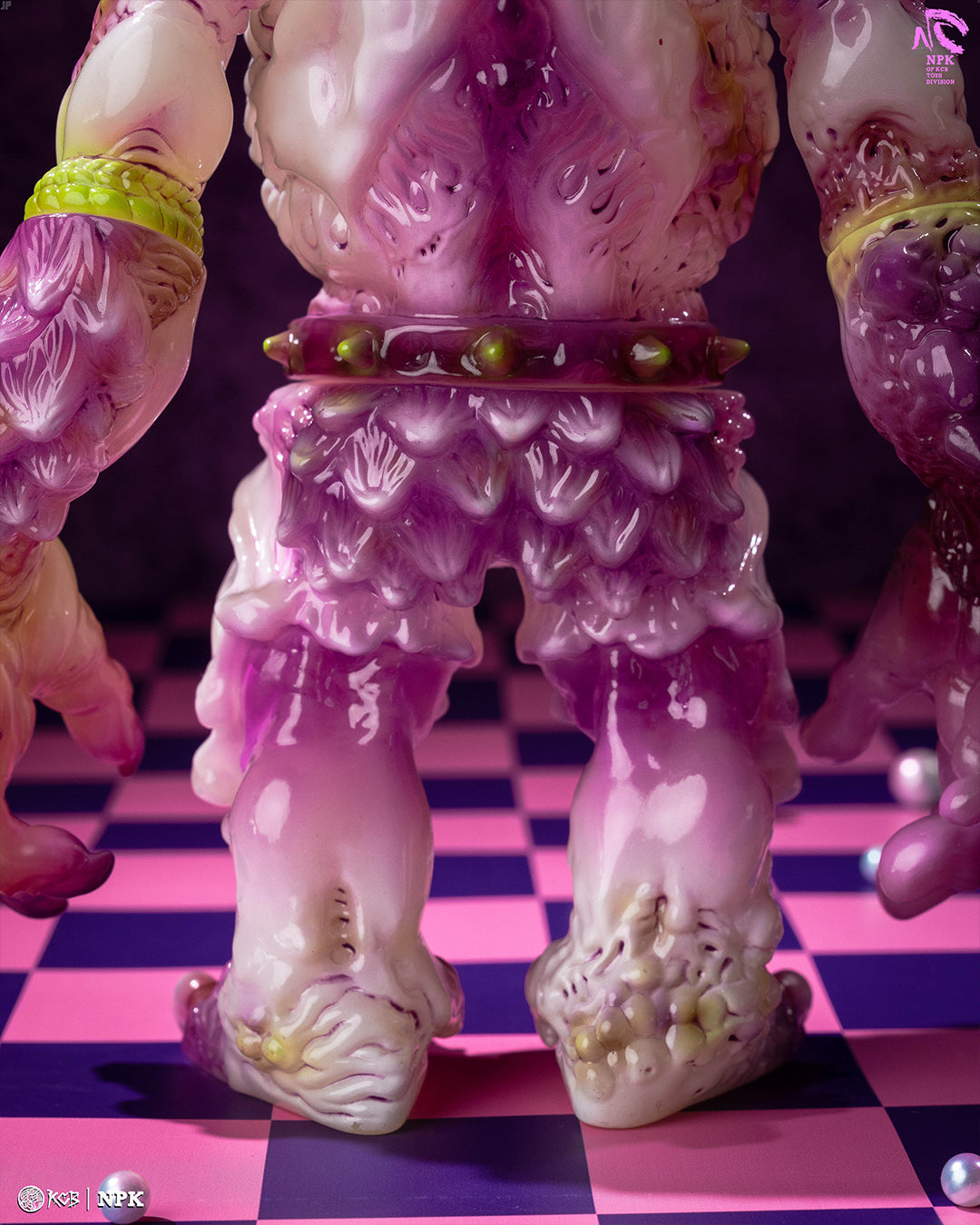 NPK · Poison Veil Ver. & Jack o’ Lantern III by KCB Toy, showcasing monster figure's textured legs, spiked belt, on checkerboard with pearls. Preorder at Strangecat Toys.