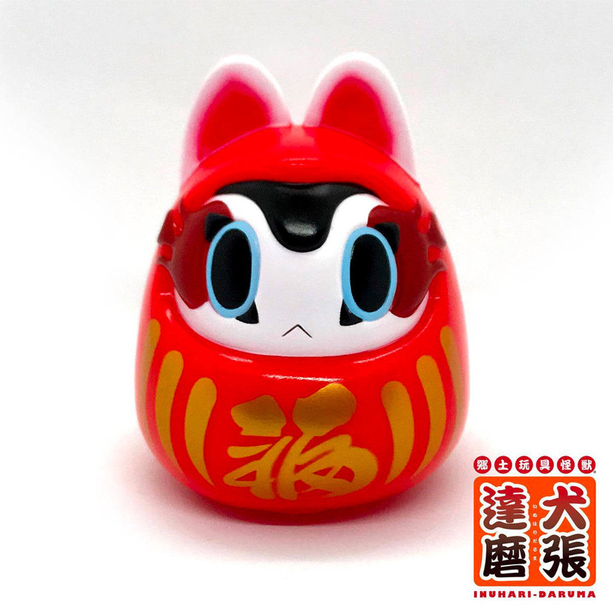 Folktoy Kaiju INUHARI-DARUMA “Red” by Teresa Chiba, a 10cm sofubi figure, features cartoon eyes, pointed ears, and gold kanji for “fortune.”