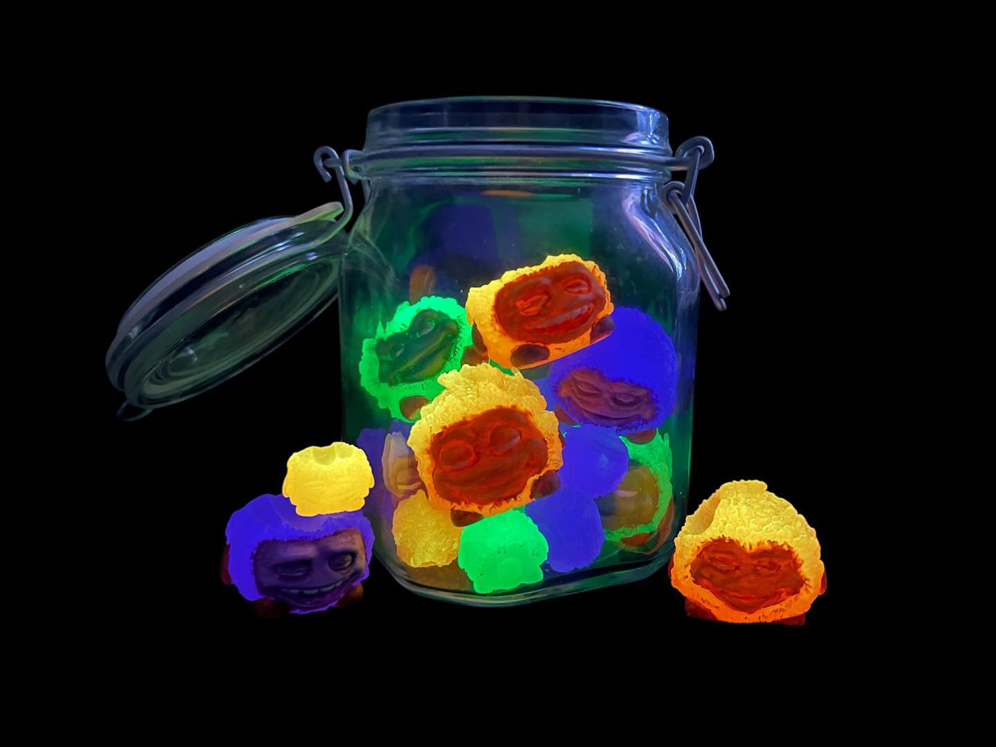 Bite Me - Bud Bites by Fettup: A jar of glowing candies featuring whimsical cartoon faces, enclosed in a clear mason jar with a lid.