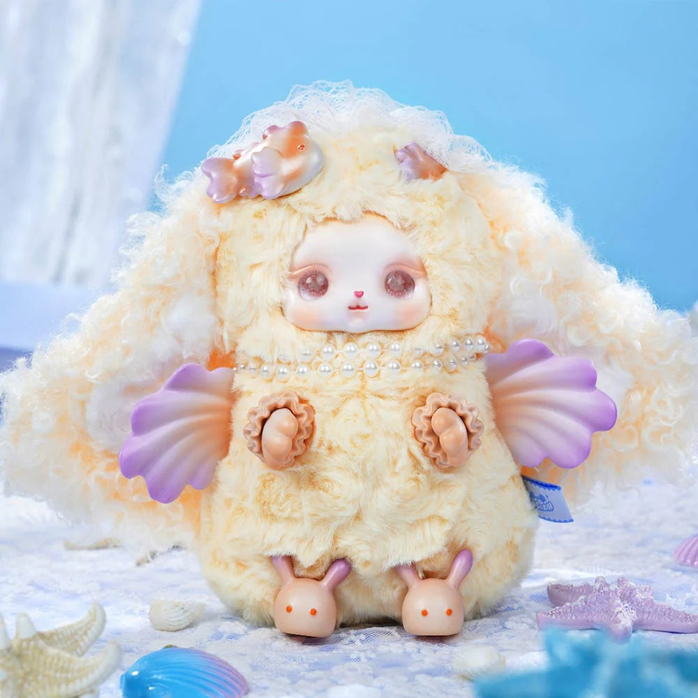 Loloan Ocean Series Plush Blind Box features a cream-colored creature with curly fur, seashell wings, pearl necklace, and bunny slippers, amidst starfish and shells.