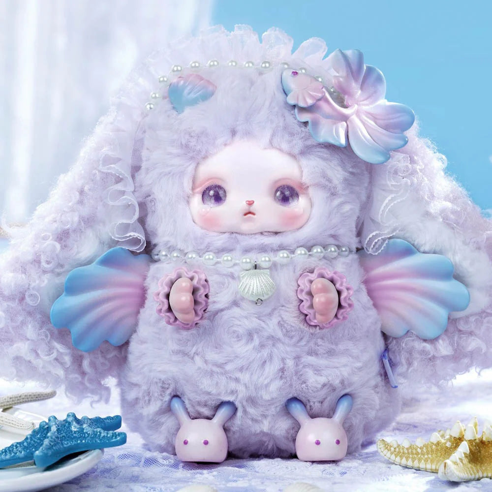 Loloan Ocean Series Plush Blind Box featuring a lavender plush with seashell details and fan-shaped arms, seated with decorative starfish on a lace surface.