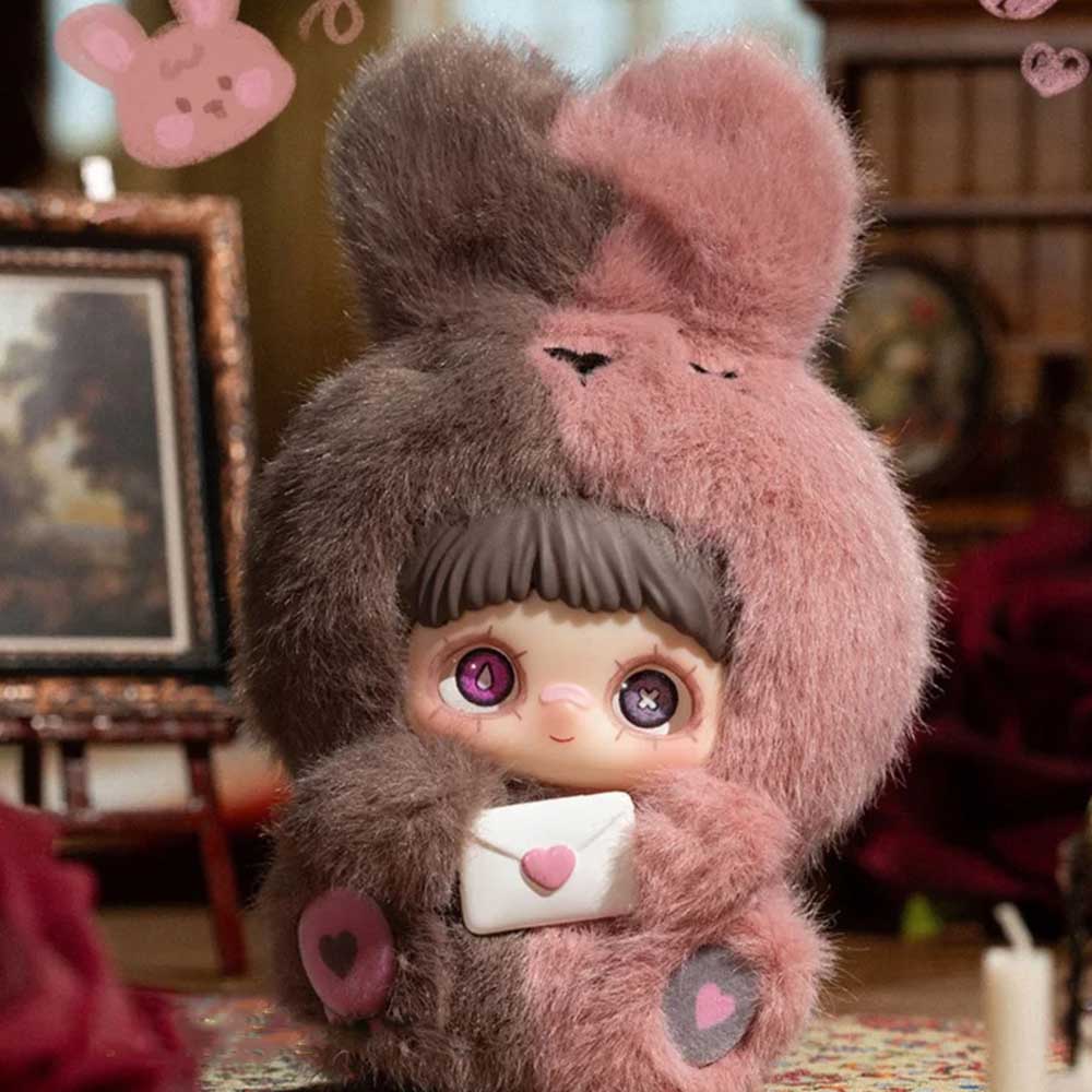 MayMei May I Love You Plush Keychain: Bunny character with mismatched eyes, clutching heart-sealed envelope, in a cozy indoor setting. Preorder from Strangecat Toys.